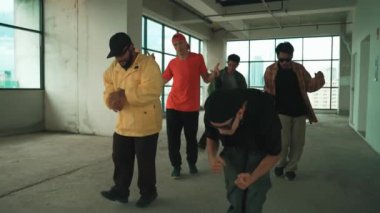 Çok kültürlü dansçılar sokak dansı yapıyor ve hip-hop müziğine geçiyorlar. Profesyonel hipster grubu gökyüzü kavgacı görünümlü bir binada serbest stil müzik eşliğinde dans ediyor. Açık hava sporu 2024 hiphop..