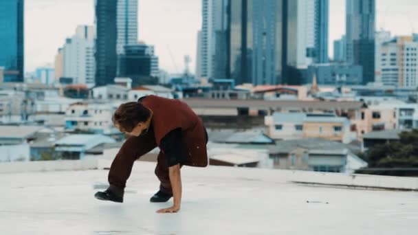 Boy舞蹈表演由专业街头舞者在屋顶上与天空碎屑 城市景观 迷人的亚洲嬉皮士表现出精力充沛的步伐 活跃的霹雳舞户外运动2024 — 图库视频影像
