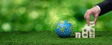 İşadamı, sürdürülebilir ve net sıfır enerji konseptiyle ESG ve karbon azaltımını sembolize ederek, kübün tepesine net sıfır kübü yerleştirdi. Panorama Güvenliği