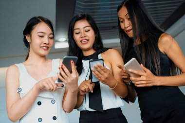 Üç kadın arkadaş ellerinde cep telefonuyla sohbet ediyorlar. Sosyal medya, dedikodu haberleri ve online alışveriş kavramı. uds