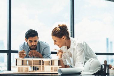 Akıllı beyaz mimar mühendis takımı ev modelini ölçmek için birlikte çalışıyor. Bir grup profesyonel iç mimar tasarım inşaatı hakkında fikir paylaşımı ve beyin fırtınası yapıyor. İzleme.