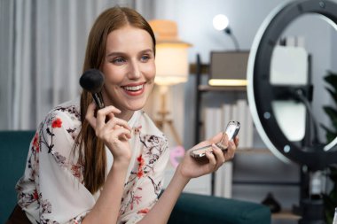 Kadın Etkilenen Vlog video görüntülerini sosyal medya ya da blog 'da en üst düzeyde yayınlıyor. Kozmetik stüdyosu ışıklandırmalı mutlu genç kız çevrimiçi pazarlama oturumu yayını için..