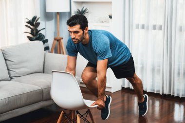 Atletik vücut ve aktif sporcu, sağlıklı vücut çalışma yaşam tarzı konsepti olarak neşeli ev egzersizlerinde kas kazanma egzersizi yapmak için mobilyaları kullanıyor..