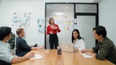 Genç liderin kapanışı, proje hakkında beyin fırtınası yapan meslektaşı ve proje yöneticisi tarafından çevrelenmiş zihin haritası ve renkli yapışkan notlar kullanılarak kendinden emin bir şekilde iş projesini sunuyor. Tertemiz..