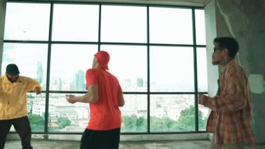 Çok kültürlü hipster grubu kameraya bakarken gökyüzü avcısıyla ya da şehir manzaralı bir binada break dans yapıyorlar. Sokak dansçısı ekibi dansçı performansına bakıyor. Açık hava sporu 2024 hiphop..