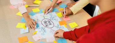 Yaratıcı iş adamları, zihin haritalama kullanarak pazarlama stratejisi ve iş planı hakkında beyin fırtınası yapıyorlar. Girişim ekibi kağıda yazmak için birlikte çalışır. Eline odaklan. - Yakın çekim. Değiştirilmiş.