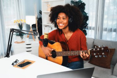 Yayın stüdyosunda gitar çalarak şarkı söyleyen Afrikalı güzel bir kadının sunucu kanalı. Canlı sosyal medyada müzik blogcusu zamanı. Ses yaratıcısı kavramı. Tatlandırıcı.