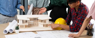 Mimari takım analizi ve ev modeli, plan ve mimari ekipmanlarla toplantı masasında ev inşaatı hakkında beyin fırtınası. Yaratıcı tasarım ve takım çalışması. Filizlenen.