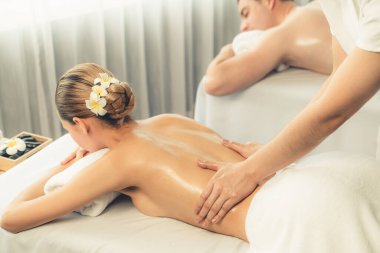 Kafkas çift müşterisi stres önleyici spa masajının keyfini çıkarıyor ve lüks otel veya oteldeki gündüz açık hava ortamında güzellik teniyle eğleniyor. Sessiz.