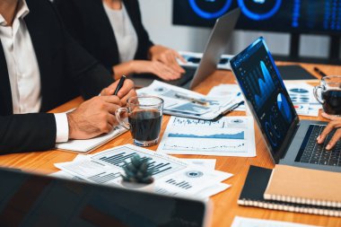 Ofis masasındaki finansal veri raporlarını analiz eden çeşitli bir grup iş analisti. Stratejik pazarlama planlaması için iş istihbarat analizine göre grafikler ve grafikler.