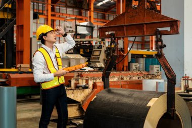 Makine operatörü çelik üretim makinelerini ustalıkla çalıştırıyor, metal fabrikasındaki ağır inşaat mühendisliği malzemeleri için silindir rulo çelik üretiyor. Örnek gösteriliyor