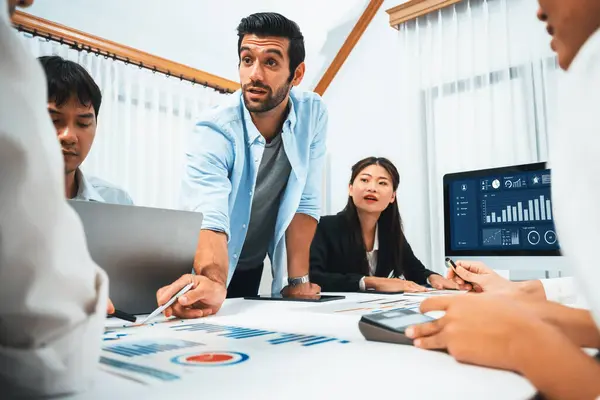 Stock image Analyst team utilizing BI Fintech to analyze financial data at table in meeting room. Businesspeople analyzing BI dashboard power for business insight and strategic marketing planning. Prudent