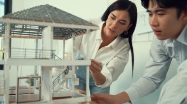 Profesyonel kooperatif beyaz mimar mühendis ekibi ev modelini dikkatle incelerken beyaz modern ofisteki model yapısı hakkında tartışırlar. Yaratıcı karar ve takım çalışması. - Yakın çekim. Tertemiz..
