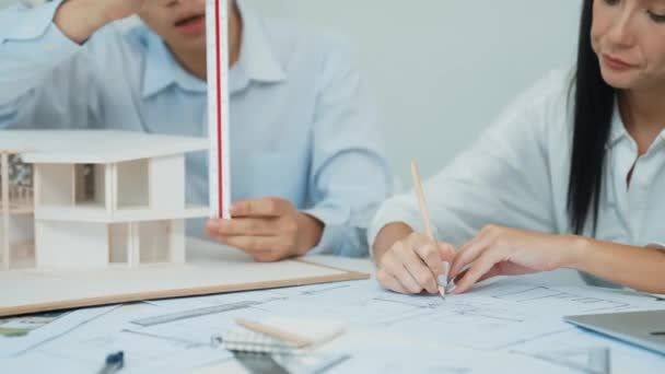 Profesionální Inženýr Měří Model Domu Zatímco Kvalifikovaný Návrhář Zapisuje Plánu — Stock video