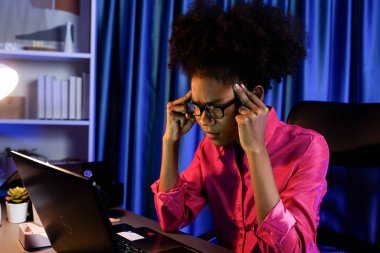 Çalışan Afrikalı kadın blogcu ciddi bir yüzle dizüstü bilgisayara yoğunlaştı, pazarlama veri analizlerini araştırdı, veri tabanındaki genel belge toplantı raporu için toplandı. Tatlandırıcı.