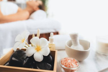 Aromaterapi masajı gündüz atmosferinde ya da spa salonunda bulanık bir kadına odak dekor ve spa aksesuarları kurarak tatil köyünde ya da otel arka planında keyifli aroma spa masajı yapan bir masaj. Sessiz.