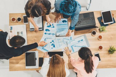 Modern ofisteki iş adamları ve iş kadınlarıyla grup toplantısındaki iş adamlarının en üst düzey görüşü, masada dizüstü bilgisayar, kahve ve belge ile. Kurumsal şirketler uds