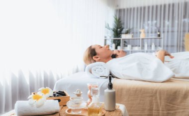 Aromaterapi masajı gündüz atmosferinde ya da spa salonunda bulanık bir kadına odak dekor ve spa aksesuarları kurarak tatil köyünde ya da otel arka planında keyifli aroma spa masajı yapan bir masaj. Sessiz.