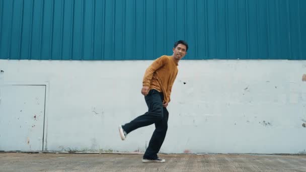 Іспаномовний Чоловік Розтягує Зброю Танцює Вулиці Перед Стіною Рухомий Знімок — стокове відео