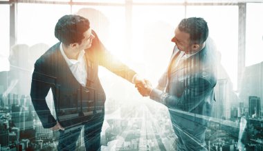 İş adamlarının arka plandaki belediye binasında el sıkışması ortaklık anlaşmasının başarısını gösteriyor. Kurumsal takım çalışması, güven ortağı ve iş anlaşması kavramı. uds