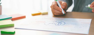 Yetenekli iş adamları zihin haritaları kullanarak pazarlama fikirleri üretiyor. Başarılı erkek girişim lideri masaya yapış yapış notlar serpiştirerek finansal plan hazırlıyor. - Yakın çekim. Eline odaklan. Değişik..