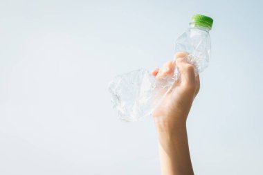 Geri dönüşümlü plastik şişe gökyüzü arka planında el ele tutulur. Geri dönüşüm için plastik atık bulundurmak etkili geri dönüşüm yönetimi ile temiz çevreyi desteklemek için konsepti azaltmak ve yeniden kullanmak. Döngü