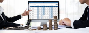 Kurumsal muhasebeci, vergi iadelerini hesaplamak ve maksimuma çıkarmak için dizüstü bilgisayar üzerinde muhasebe yazılımı kullanır ve Panorama 'daki iş yatırım yığını madeni para konseptiyle finansal performansı artırır. Kurnaz.