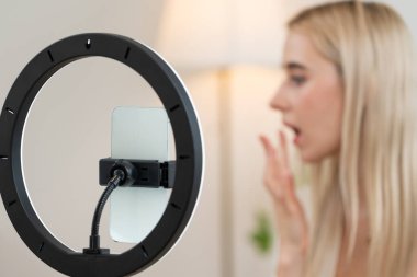 Sosyal medya için güzellik ve kozmetik video içeriği hazırlayan bulanık genç bir kadın. Güzellik etkileyicisi seyircilere ya da takipçilere güzellik hizmetinin nasıl uygulanacağını gösterirken odaklanmış kamera. Blithe