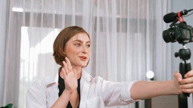 Kadın nüfuzlu kişi video görüntülerini canlı yayınlıyor. Kıyafetler sosyal medyada ya da blogda yer alıyor. Stüdyo ışıklandırmalı mutlu genç kız çevrimiçi pazarlama oturumu yayını için..