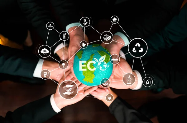 Business partnership holding Earth globe together with eco design icon symbolize ESG sustainable environment protection with eco technology and carbon credit solution for net zero ecosystem. Reliance