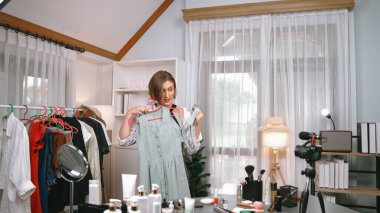 Kadın nüfuzlu kişi video görüntülerini canlı yayınlıyor. Kıyafetler sosyal medyada ya da blogda yer alıyor. Stüdyo ışıklandırmalı mutlu genç kız çevrimiçi pazarlama oturumu yayını için..