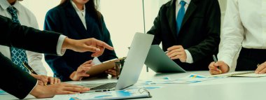 Grup toplantısındaki iş adamları resmi kıyafet paylaşımı fikrine sahipler. Şirketin yaratıcı çalışma alanındaki kar raporunu tartışıyorlar. Grup toplantısı masasında yakın çekim yapmak için. Konuşma .