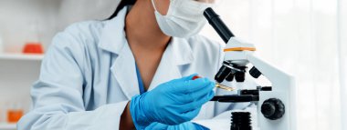 Laboratuvar araştırmacısı mikroskop kullanarak yeni ilaç ya da tedavi geliştirir. Laboratuvar mikrobiyoloji ekipmanları ile bilimsel uzmanlık ile sağlık hizmetlerinin teknolojik gelişimi. Panorama Katı