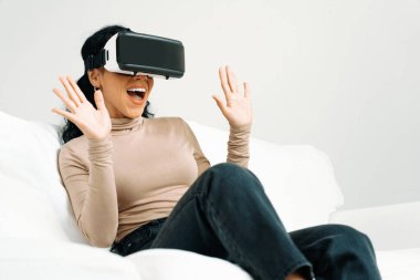 Sanal gerçeklik gözlüğü kullanan genç bir kadın çok önemli online alışveriş deneyimleri için evde. Sanal gerçeklik VR yeniliği kadın dijital eğlence yaşam tarzı için optimize edildi.