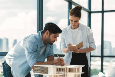 Akıllı beyaz mimar mühendis takımı ev modelini ölçmek için birlikte çalışıyor. Bir grup profesyonel iç mimar tasarım inşaatı hakkında fikir paylaşımı ve beyin fırtınası yapıyor. İzleme.