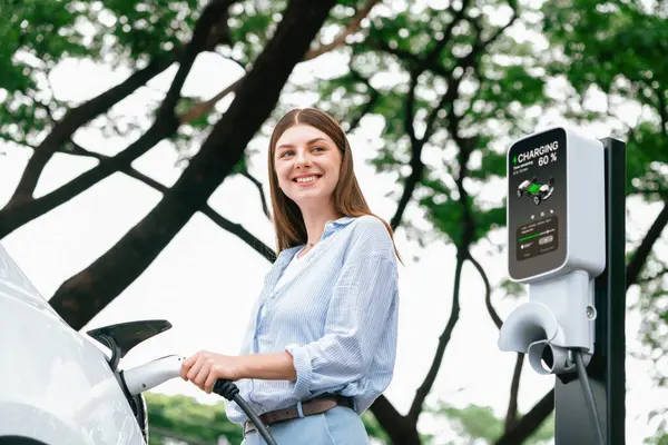 Jonge Vrouw Opladen Batterij Voor Elektrische Auto Tijdens Weg Reis — Stockfoto