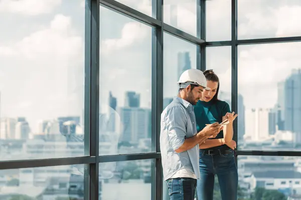 stock image Professional smart architect engineer team discuss and solve building construction problems. Engineer taking a note while listening manager sharing idea about work surrounded by skyscraper. Tracery.