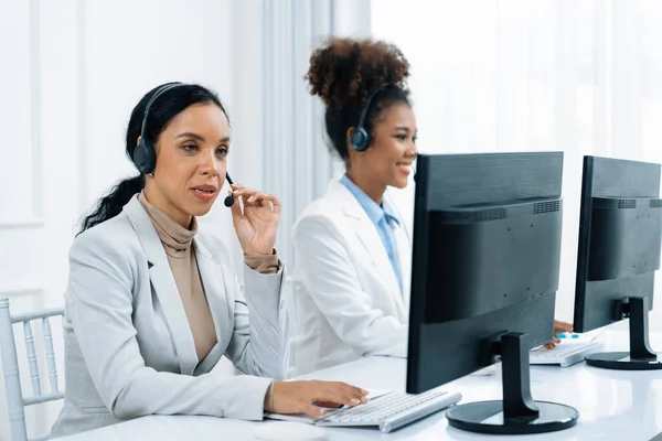 Business people wearing headset working in office to support remote customer or colleague. Call center, telemarketing, customer support agent provide service on telephone video conference call crucial