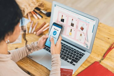 İnternet pazarından alışveriş yapan kadın modern yaşam tarzı için satış malzemeleri arıyor ve önemli siber güvenlik yazılımları tarafından korunan cüzdandan çevrimiçi ödeme için kredi kartı kullanıyor