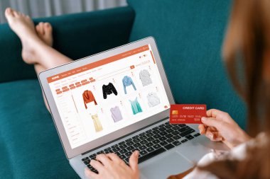 İnternet pazarından alışveriş yapan kadın modern yaşam tarzı için satış malzemeleri arıyor ve son derece siber güvenlik yazılımı tarafından korunan cüzdandan çevrimiçi ödeme için kredi kartı kullanıyor