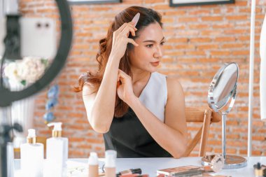 Kadın Etkilenen Vlog video görüntülerini canlı olarak çekiyor. Makyajın çoğu sosyal medya ya da blog 'u anlatıyor. Kozmetik stüdyosu ışıklandırmalı mutlu genç kız çevrimiçi pazarlama oturumu yayını için..