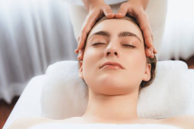 Kafkasyalı kadın stres önleyici kafa masajından ve lüks tatil beldesi ya da otel spa salonundaki modern ışık ortamında yüz güzelliği eğlencelerini şımartmaktan hoşlanıyor. Sessiz.