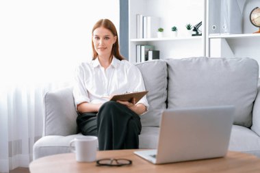 Klinikteki psikolog kadın. Profesyonel portresi. Dostane gülümsemesiyle hastayı psikoloğa davet ediyor. Tecrübeli ve kendine güvenen psikolog son derece uzmandır.