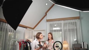 Etkilenen iki ortak canlı yayında video görüntülerini çekiyor makyaj malzemesi prim sosyal medya veya blog. Kozmetik stüdyosu ışıklandırmalı mutlu genç kız çevrimiçi pazarlama oturumu yayını için..