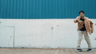 İspanyol komedi koreografı hip hop tarzında dans ediyor. Genç mutlu break dansçı B-boy dansı yapıyor. Sokak dansı yapan komik adamın hareket çekimi. Açık hava sporu 2024. Modern dans. hiphop.