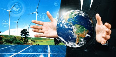 Alternatif enerji ile sürdürülebilirlik gelişimi kavramı. Çevre dostu rüzgar türbini çiftliği ve arka planda yeşil yenilenebilir enerji olan gezegenle insan eli ilgilenir. uds
