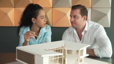 Profesyonel mimar mühendis takımı ev modeli inşaatı hakkında konuşuyor. Ev malzemesi ve yapı sorunları konusunda uzman proje yöneticisi beyin fırtınası yapıyor. İş tasarımı konsepti. Yönlendirici.