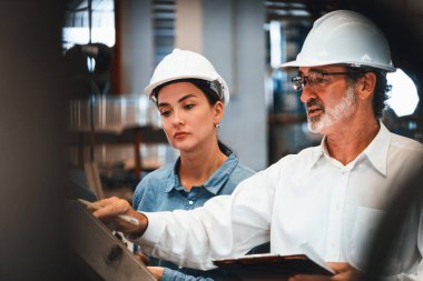 Fabrika müdürü endüstriyel çelik makinelerini teftiş ediyor ve denetliyor. Metal maddi ürün için kalite kontrol sürecini denetliyor ve geliştiriyor. Örnek gösteriliyor