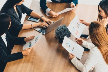 Modern işyeri ofisindeki diğer iş kadınlarıyla grup toplantısındaki iş kadını masada dizüstü bilgisayar ve belgelerle konuşuyor. Kurumsal iş dünyası konsepti. uds