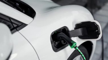 Şarj istasyonundan çevre dostu araba şarj oluyor. Fütürist hologram görüntü bataryası durumu. Alternatif enerji teknolojisinde son gelişmeler ve şarj edilebilir EV araba. İnceleyin